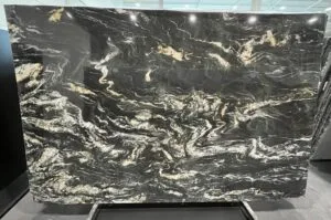 Grande dalle de pierre noire veinée d'or présentée sur son rack
