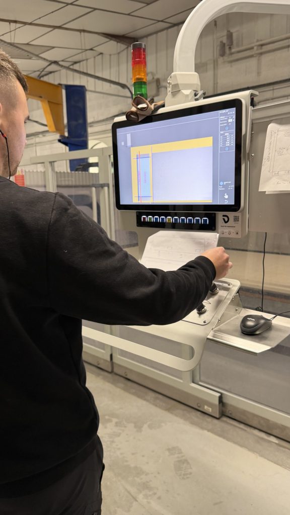 Opérateur pilotant une machine de découpe depuis son écran de commande